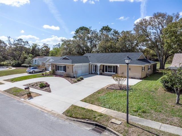 ranch-style house featuring a garage, concrete driveway, and a front lawn