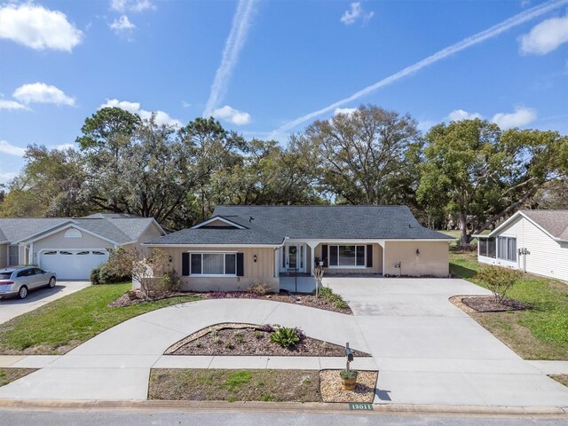 ranch-style home featuring a front lawn and concrete driveway