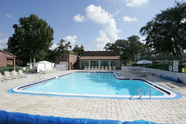 community pool featuring a patio area and fence