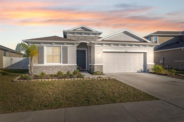 view of front of property featuring an attached garage, stone siding, and stucco siding