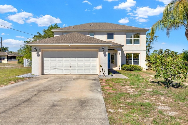 traditional-style home featuring a garage, concrete driveway, a front yard, and stucco siding