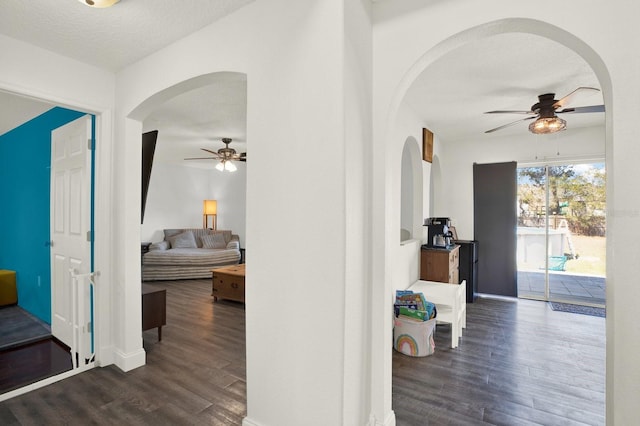 hall with a textured ceiling, wood finished floors, and baseboards