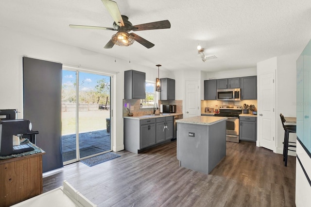 kitchen featuring stainless steel appliances, light countertops, dark wood-type flooring, and gray cabinetry