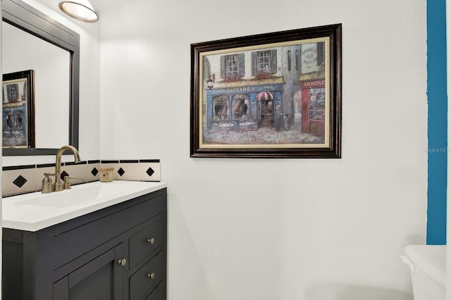 bathroom with toilet, tasteful backsplash, and vanity