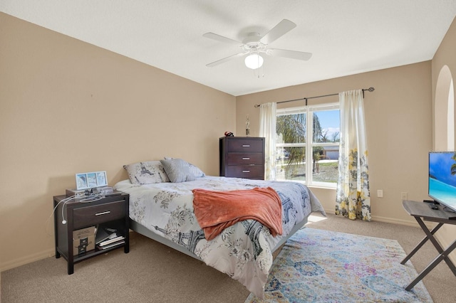 bedroom with a ceiling fan, baseboards, arched walkways, and carpet flooring