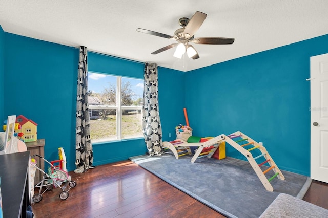 rec room with hardwood / wood-style flooring, a textured ceiling, and a ceiling fan