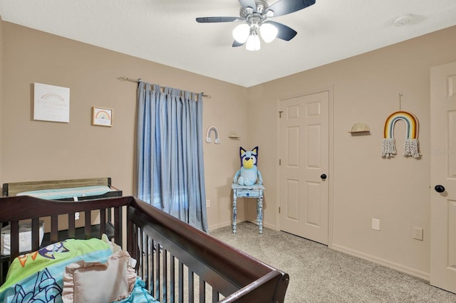 carpeted bedroom with ceiling fan and baseboards