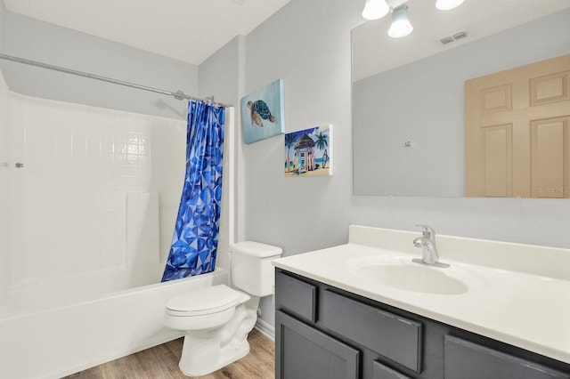 bathroom featuring toilet, wood finished floors, vanity, visible vents, and shower / bath combination with curtain