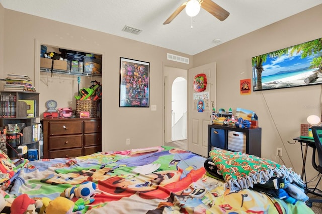 bedroom with ceiling fan, visible vents, arched walkways, and a closet