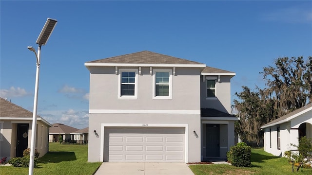 traditional-style home with an attached garage, stucco siding, concrete driveway, and a front yard