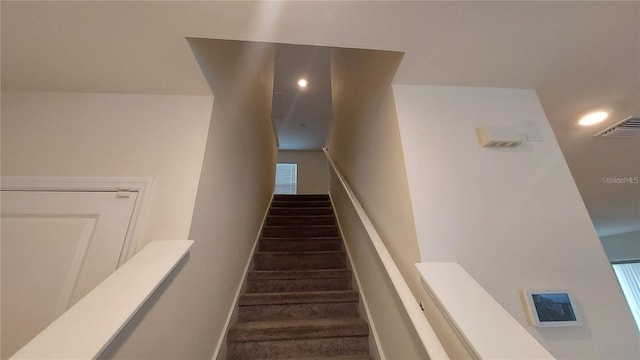 staircase featuring baseboards and visible vents