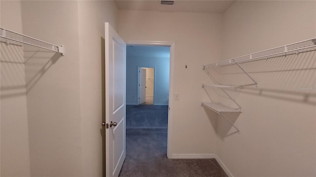 walk in closet featuring dark carpet and visible vents