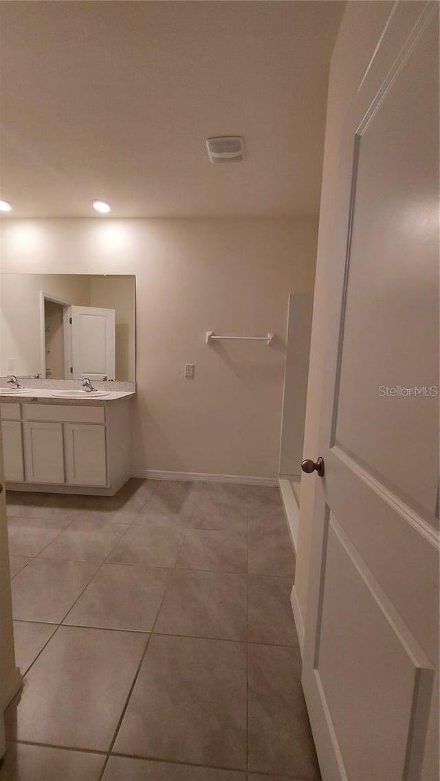 bathroom featuring recessed lighting, a sink, baseboards, tile patterned floors, and double vanity