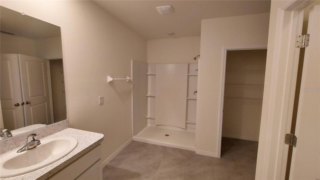 full bathroom featuring a stall shower, tile patterned flooring, baseboards, and vanity