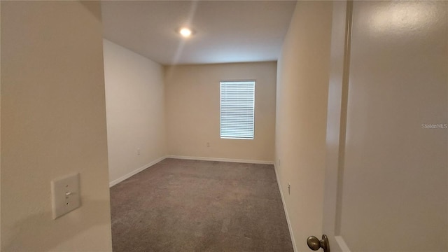 empty room featuring carpet flooring and baseboards