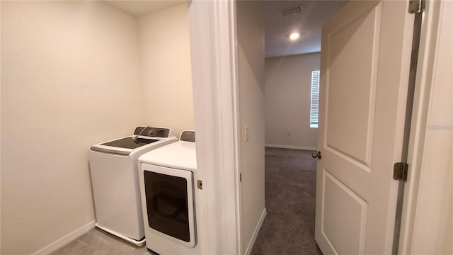 clothes washing area featuring washer and dryer, laundry area, visible vents, and baseboards