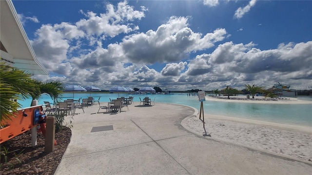 view of pool featuring a water view and a patio