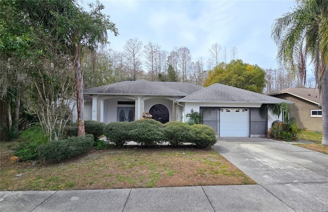 ranch-style house featuring driveway, an attached garage, and stucco siding