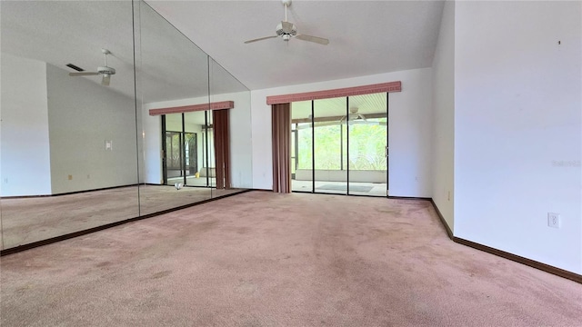 carpeted empty room featuring high vaulted ceiling, ceiling fan, and baseboards