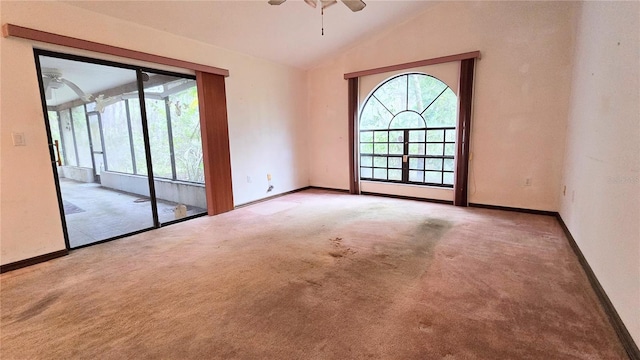 carpeted spare room with baseboards, vaulted ceiling, and a ceiling fan