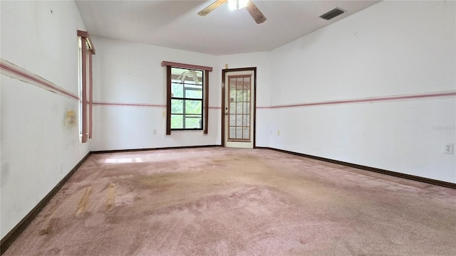 empty room featuring carpet floors, baseboards, visible vents, and a ceiling fan