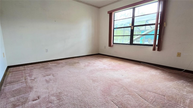 empty room featuring carpet and baseboards