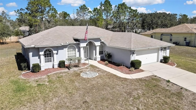 view of front of property with a garage, driveway, stucco siding, roof with shingles, and a front yard