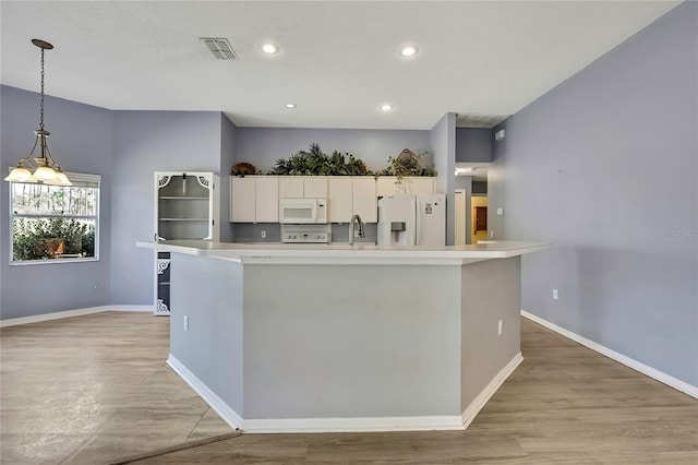 kitchen with light countertops, white appliances, a sink, and white cabinetry