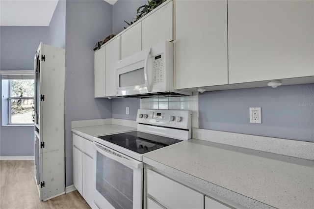 kitchen with white cabinets, white appliances, baseboards, and light countertops