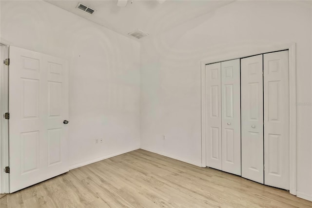 unfurnished bedroom with a closet, visible vents, light wood-style flooring, and baseboards