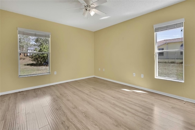 unfurnished room with light wood-style flooring, baseboards, and ceiling fan