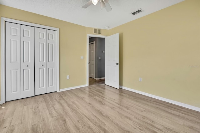 unfurnished bedroom with visible vents, light wood-style flooring, and baseboards