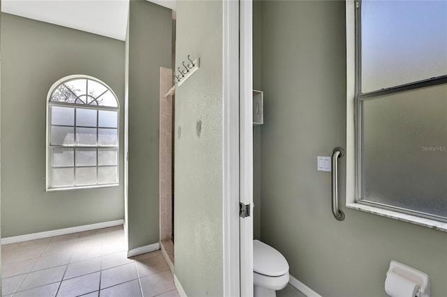 full bath with toilet, baseboards, walk in shower, and tile patterned floors