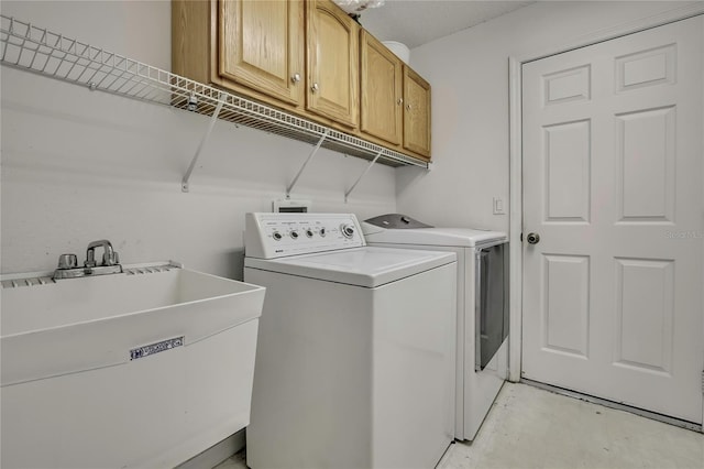 laundry area featuring cabinet space, a sink, and independent washer and dryer