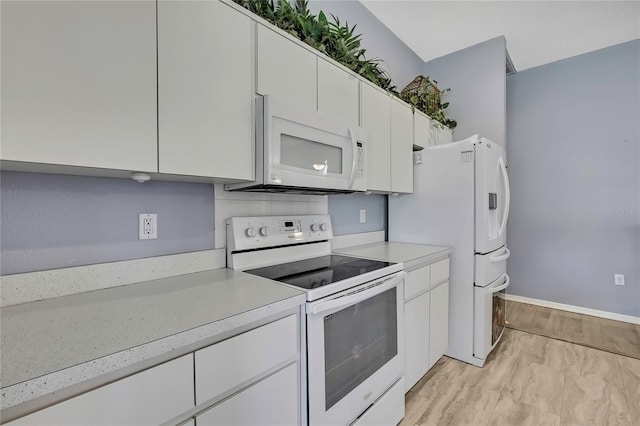 11257 Frigate Bird Ave, Weeki Wachee, FL 34613 - kitchen featuring white appliances, light countertops, and white cabinetry