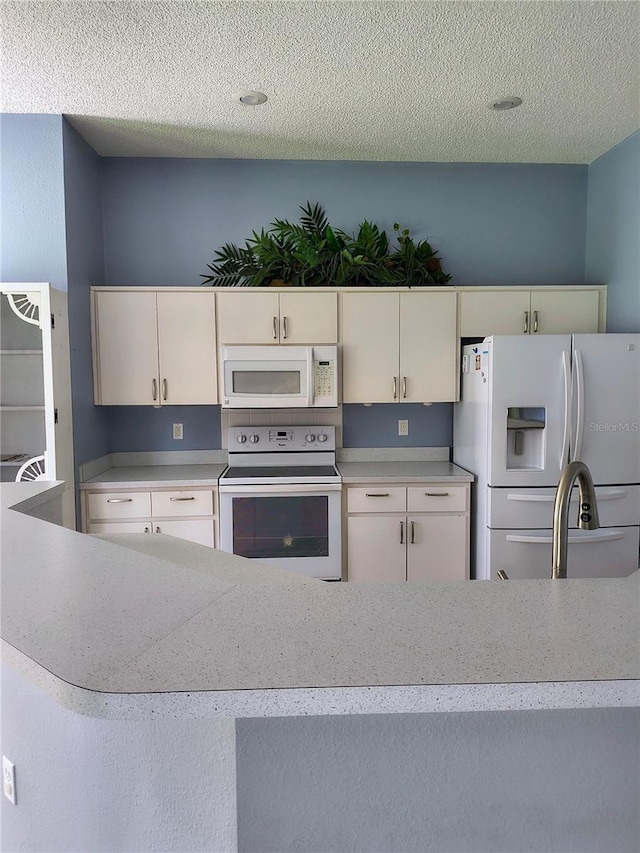 11257 Frigate Bird Ave, Weeki Wachee, FL 34613 - kitchen with white appliances, light countertops, white cabinetry, and a textured ceiling