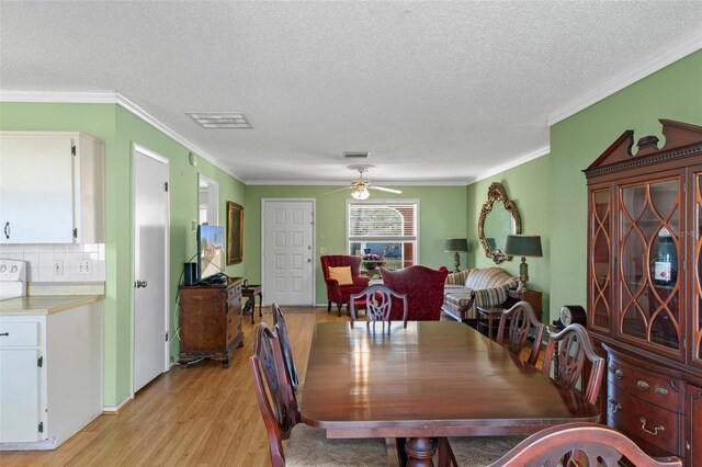 dining space featuring crown molding, visible vents, light wood finished floors, and ceiling fan