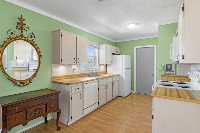 kitchen with white appliances, a sink, light countertops, white cabinetry, and light wood-type flooring