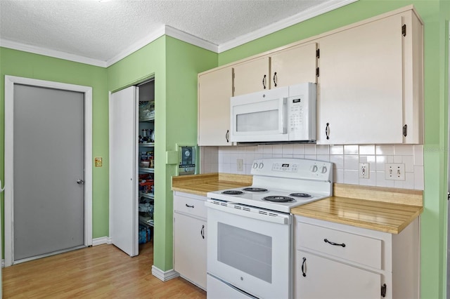 kitchen featuring backsplash, crown molding, light countertops, light wood-style floors, and white appliances