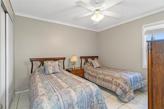 bedroom featuring a textured ceiling, a closet, crown molding, light tile patterned floors, and ceiling fan