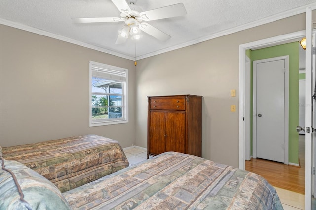 bedroom featuring ceiling fan, crown molding, baseboards, and a textured ceiling