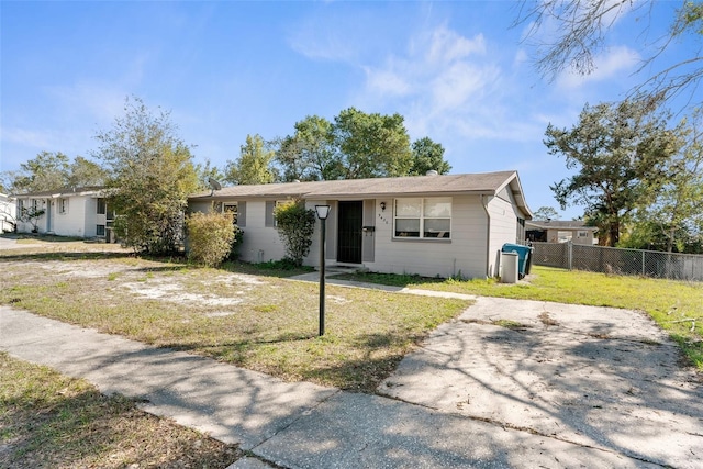 ranch-style house featuring a front lawn and fence