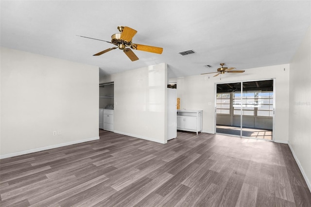 unfurnished living room featuring visible vents, a ceiling fan, wood finished floors, washer and dryer, and baseboards