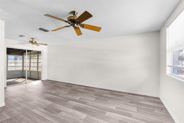 spare room featuring visible vents, baseboards, and wood finished floors