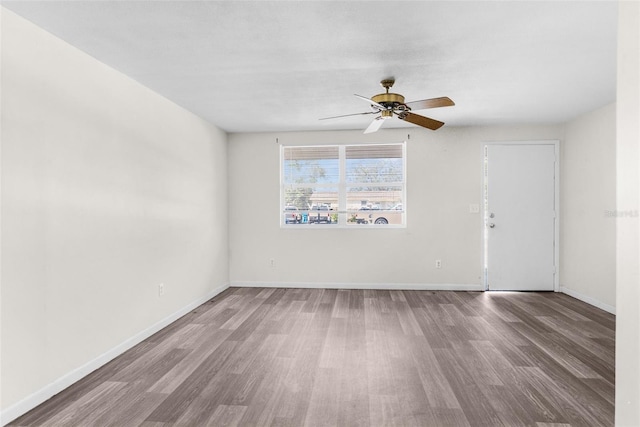 unfurnished room featuring a ceiling fan, baseboards, and wood finished floors