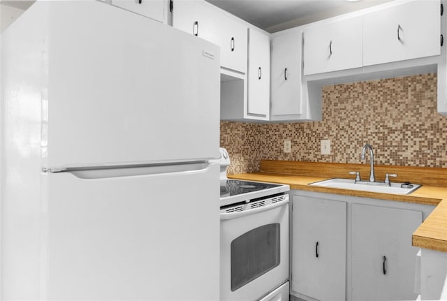 kitchen featuring white appliances, light countertops, a sink, and backsplash