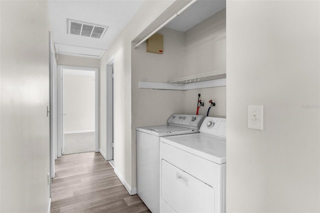 laundry area featuring visible vents, separate washer and dryer, light wood-type flooring, laundry area, and baseboards