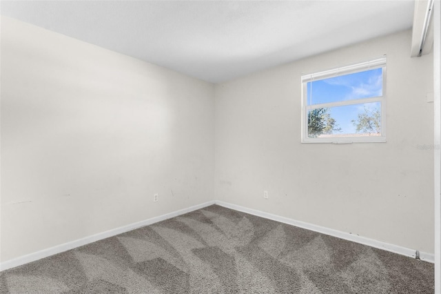 carpeted empty room featuring stairs and baseboards