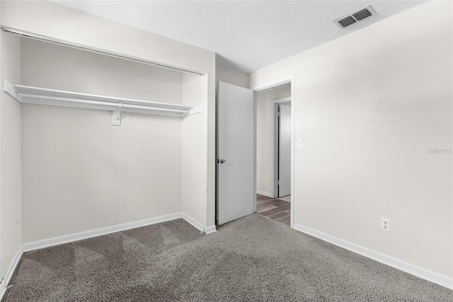 unfurnished bedroom featuring carpet floors, baseboards, visible vents, and a closet