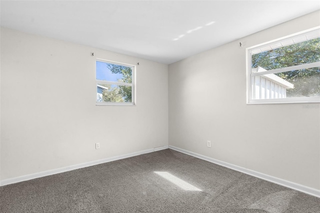 carpeted empty room featuring baseboards